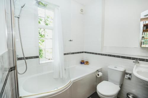 a bathroom with a tub and a toilet and a sink at Hundred House Hotel in Ironbridge
