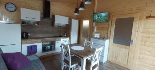 eine Küche mit einem Tisch und Stühlen in einer Hütte in der Unterkunft APARTAMENT DOMEK CAŁOROCZNY in Ciechocinek