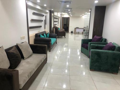 un soggiorno con divani e sedie su un pavimento piastrellato di Zafero Studios and Apartments - Families only ad Alessandria d'Egitto
