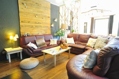 a living room with a leather couch and a table at La Babillarde in Auby-sur-Semois