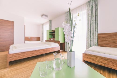 ein Schlafzimmer mit 2 Betten und einem Tisch mit Brille darauf in der Unterkunft Karlingerhaus in Königswiesen