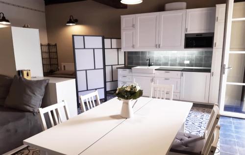 a kitchen with white cabinets and a table with a vase on it at DomasHome in Domaso