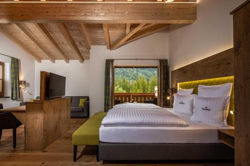 a bedroom with a large bed and a large window at Wörndlhof - Das Refugium in Ramsau