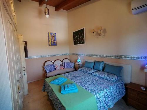 a bedroom with a bed with a blue comforter at Orange Ville in Villamassargia