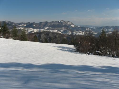 a snow covered slope with mountains in the background at Gozdarjeva koča nad Rimskimi Toplicami in Dol pri Hrastniku