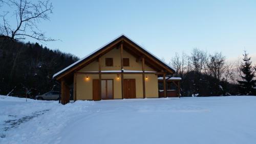 a cabin in the snow with a snow covered driveway at Gozdarjeva koča nad Rimskimi Toplicami in Dol pri Hrastniku