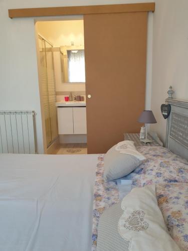 a bedroom with a bed and a bathroom with a sink at Am Meer in Ladispoli