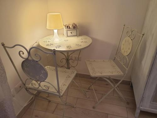 a table and a chair with a lamp and a table and a table at Am Meer in Ladispoli