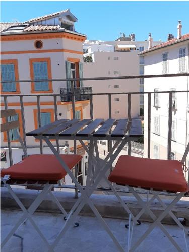 une table de pique-nique et deux chaises sur un balcon dans l'établissement Studio Suquet balcony 1 min beach, 10 min Palais & Croisette Works, à Cannes