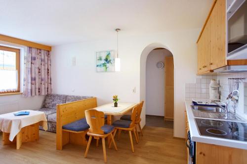 a kitchen and living room with a table and chairs at Gasthof Gröbenhof in Fulpmes