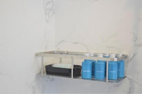 a shelf with four blue containers on a wall at Montecito Apartments in Accra