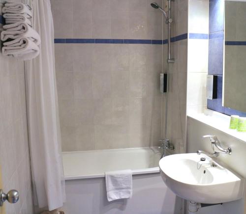 a bathroom with a tub and a sink and a shower at Campanile Barcelona in Barbera del Valles