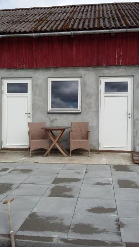 ヘルシンゲルにあるRosenlund Bed and Breakfastの二つのドア、テーブル、椅子2脚のある建物