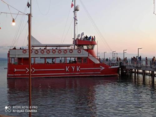 a red boat in the water next to a pier at Апартаменти Бриз 1 in Pomorie