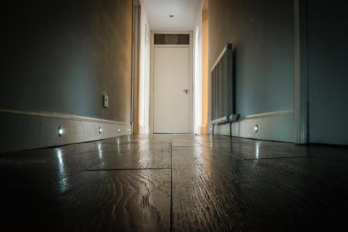 an empty room with a door and a wooden floor at Copper Oven apartments in Arbroath