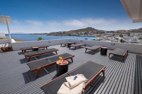 a deck with picnic tables and chairs on a balcony at Deliades Hotel in Ornos