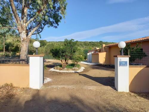 a driveway with two white gates in front of a house at DOMO DE FOLAS in Budoni