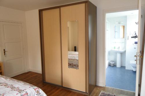 a bedroom with a sliding door with a bathroom at Domaine du Sable in Saint-Julien-aux-Bois