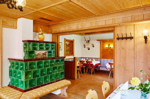 ein Wohnzimmer mit einem grünen Kamin in einem Haus in der Unterkunft Gasthof Gröbenhof in Fulpmes