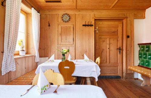 a dining room with two tables with white linens at Gasthof Gröbenhof in Fulpmes