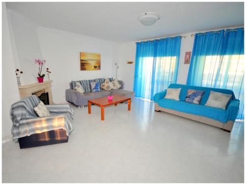 a living room with two couches and a table at Apartamentos Capitolina in Quarteira