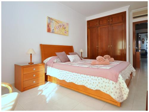 une chambre avec un lit avec deux serviettes dessus dans l'établissement Apartamentos Capitolina, à Quarteira