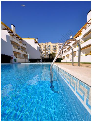 a swimming pool with a water slide in a building at Apartamentos Capitolina in Quarteira