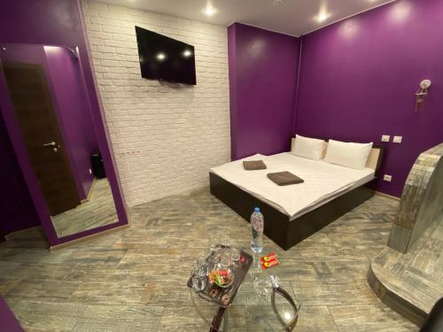 a purple room with a bed and a mirror at Мини отель Нумера in Moscow