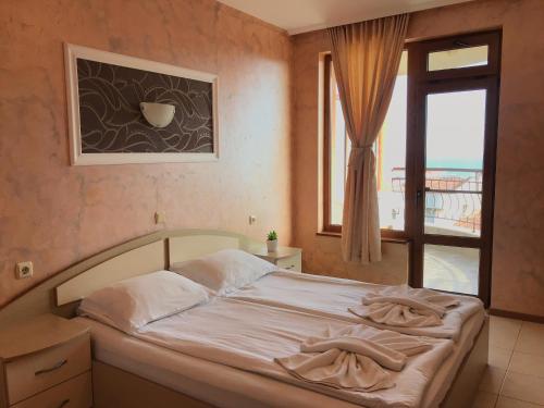 a bedroom with a bed and a window with a view at Guest House Val and Kate in Sveti Vlas