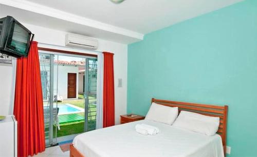 a bedroom with a bed with a television and a pool at Pousada Italia in Natal