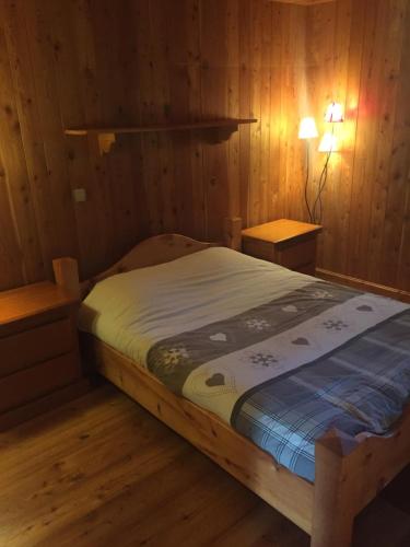 a bedroom with a bed in a wooden room at L'Atelier in Les Contamines-Montjoie
