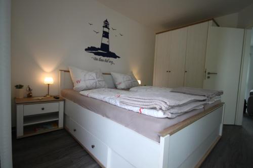 a bedroom with a bed with a lighthouse on the wall at Küstenliebe 8 in Graal-Müritz