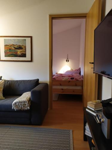 a living room with a couch and a bedroom at SchlossparkFerienwohnungen Rheinsberg mit Garten in Rheinsberg