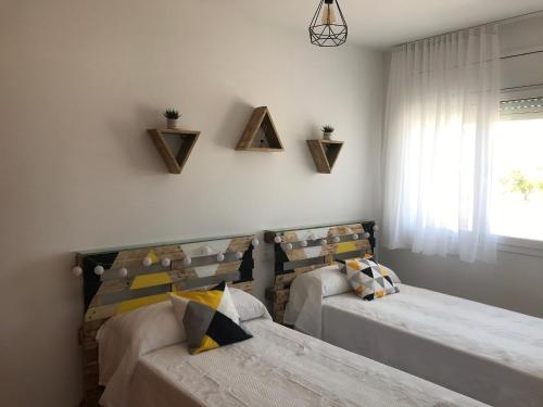 1 dormitorio con 2 camas y ventana en La Caseta del Padri, en Deltebre