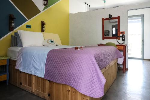 a bedroom with a large bed with a purple blanket at Pefkos Eye in Pefki Rhodes