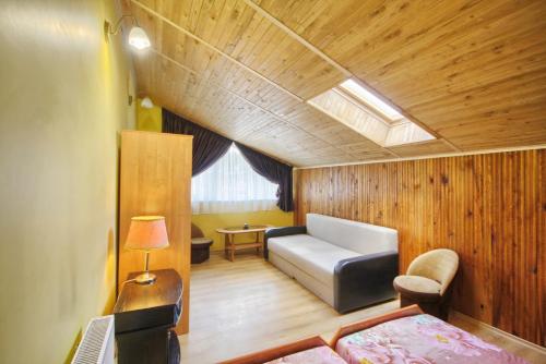 um quarto com um sofá, uma cama e uma janela em Poilsis Pas Tada em Druskininkai