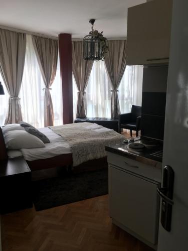 a bedroom with a bed and a television and curtains at Visoki Stevan Apartments in Belgrade