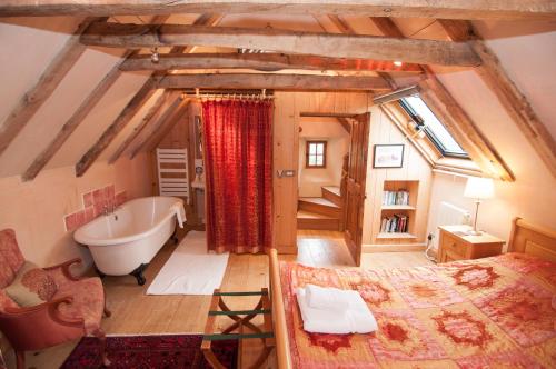 1 dormitorio con 1 cama y bañera en una habitación en Barns Tower, en Peebles