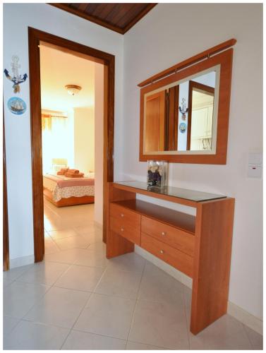 a bathroom with a wooden dresser and a mirror at Apartamentos Capitolina in Quarteira