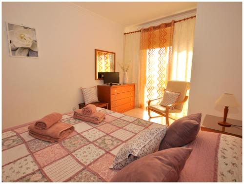a bedroom with a bed and a dresser and a window at Apartamentos Capitolina in Quarteira