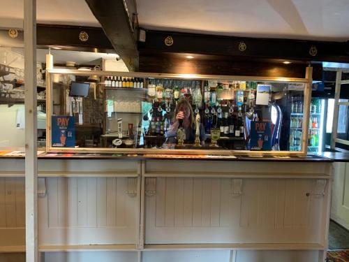 a woman standing behind a bar in a pub at The Queen Anne in Hucklow