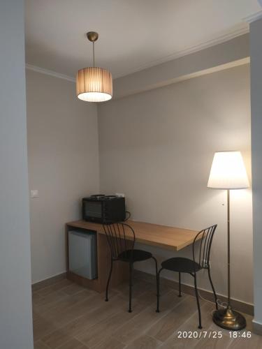 a dining room table with two chairs and a lamp at Lilly Apartments in Athens