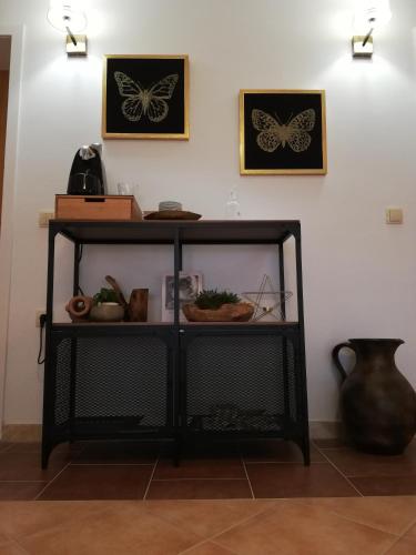 a black shelf with butterflies on the wall at Riviera Rooms and Apartments in Rab