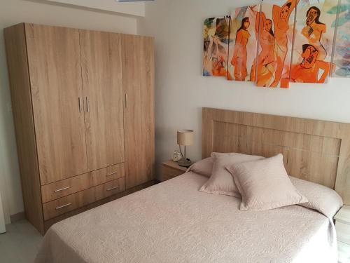um quarto com uma cama e um armário de madeira em El RiNCoNCiTo De Su em Gijón