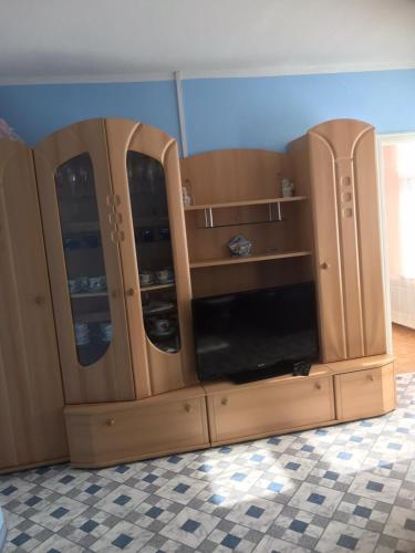 a wooden cabinet with glass doors in a room at Ferienwohnung Ils in Wittmund in Wittmund