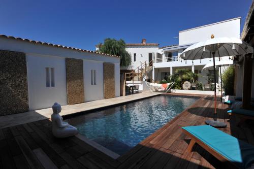 Una piscina con una sombrilla al lado de una casa. en clemente en aparté nord, en Lecci