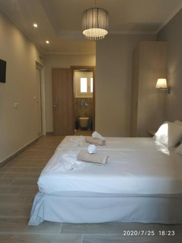 a bedroom with a large white bed with a towel on it at Lilly Apartments in Athens