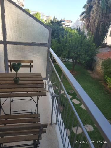 a bench with a potted plant sitting on a balcony at Lilly Apartments in Athens
