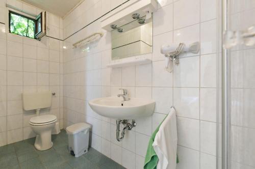 a white bathroom with a sink and a toilet at Blumenhof Wegleitner in Illmitz