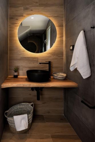 a bathroom with a sink and a mirror at Costa D' Ifesto in Agios Ioannis Kaspaka